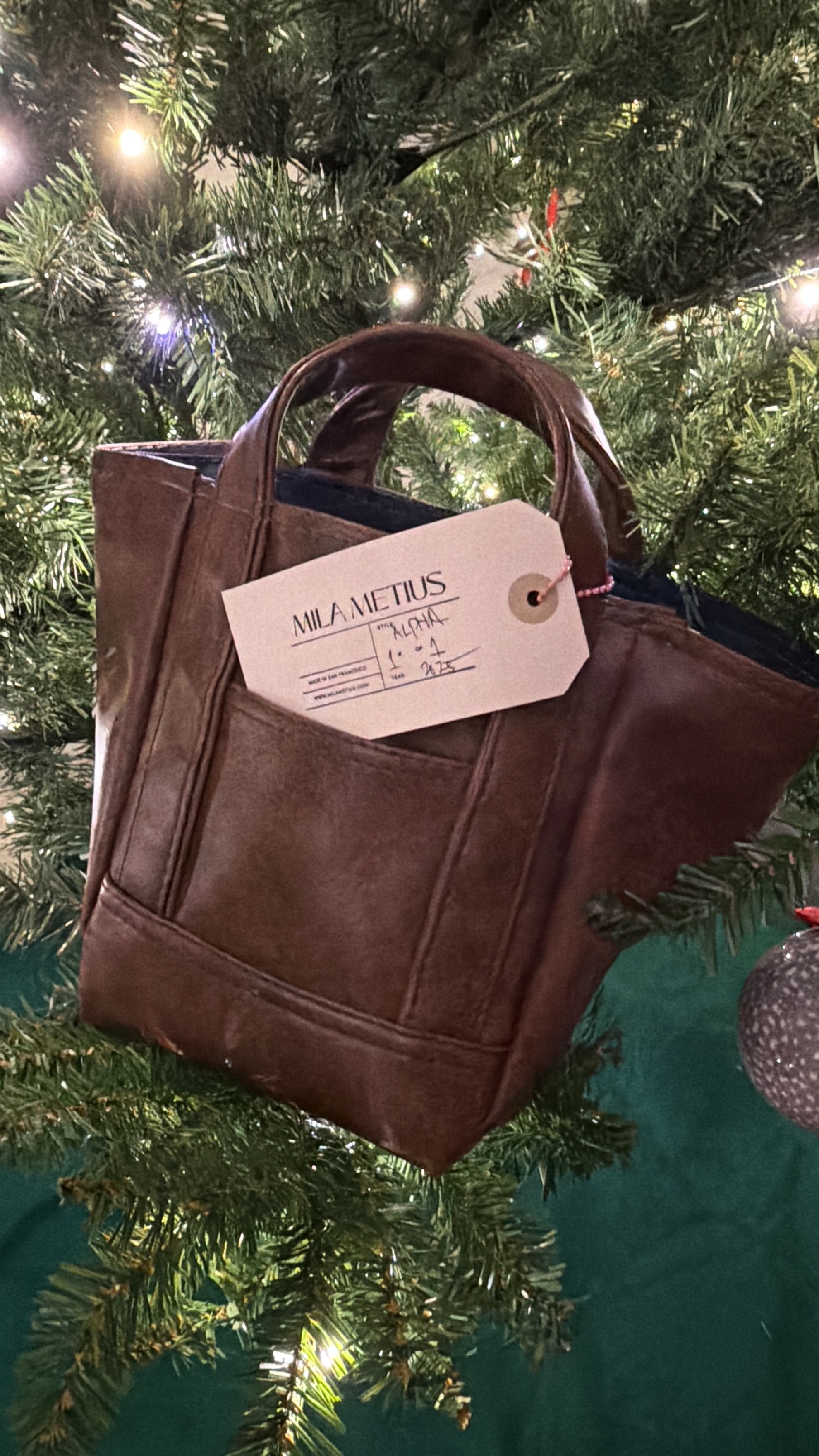 Brown tote with Mila Metius tag and plush charm